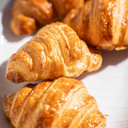 A plate of flaky, golden croissants, perfectly buttery and crisp on the outside.