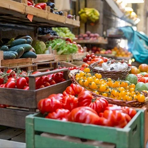A colorful outdoor market stall filled with vibrant tomatoes, peppers, and peppers in wooden crates, with fresh produce and a bustling vibe.