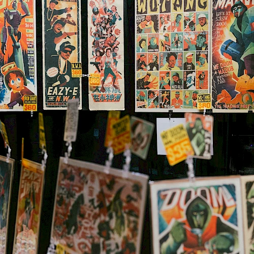 A display of vintage comic book covers and pages hanging for sale, colorful artwork with superhero and character panels, tags attached.