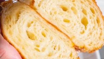 Soft, fluffy bread with a light golden crust, torn in half to reveal airy, bubbly interior.